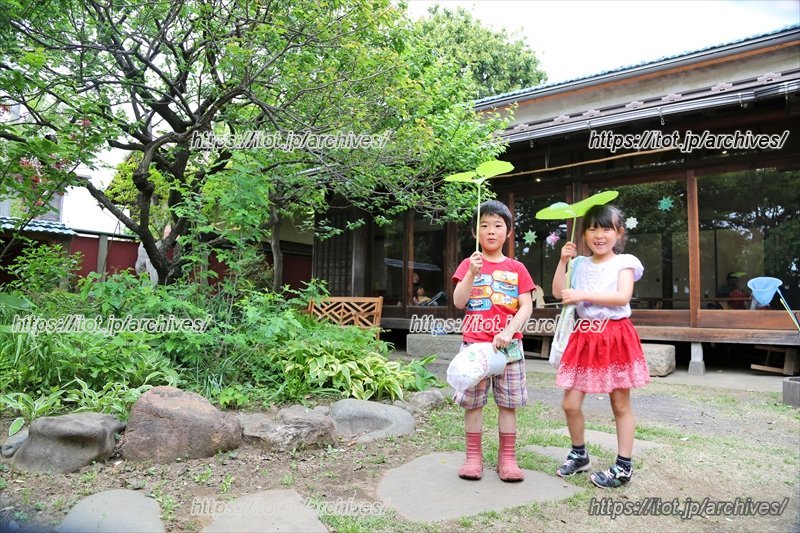 「やぼろじ」の庭で、葉っぱを傘にする子どもたち