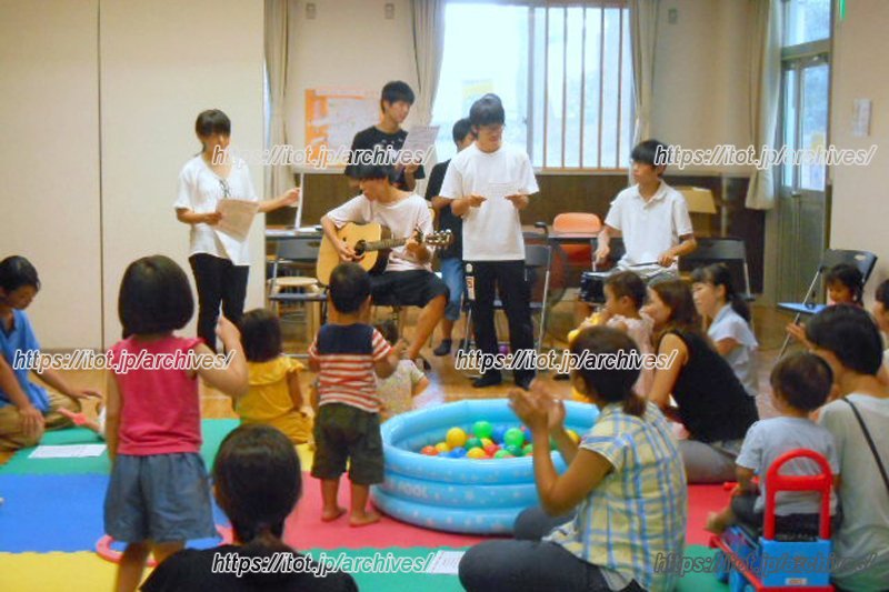 幼児のために「アンパンマン」の曲を演奏する高校生