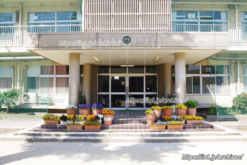 綺麗な花が飾られた明るい校舎入口

