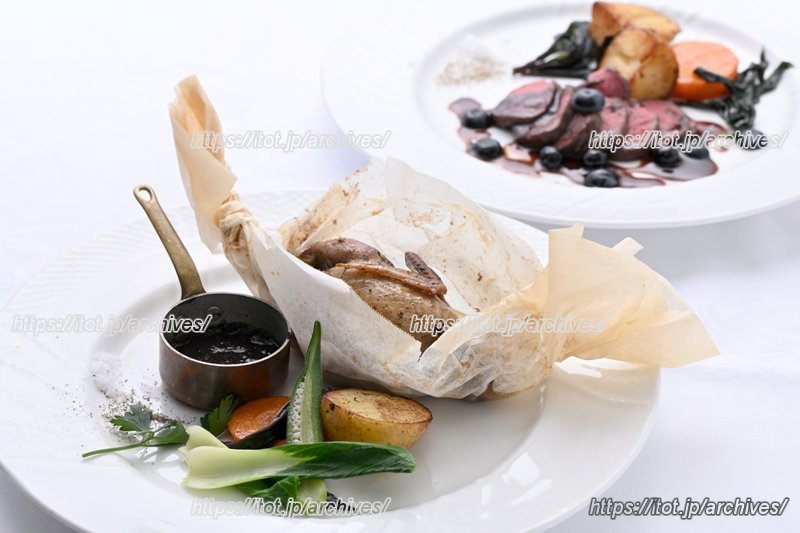 ウズラの紙包焼きと、奥に見える、ブルベリーソースでいただく小鹿のバターソテー