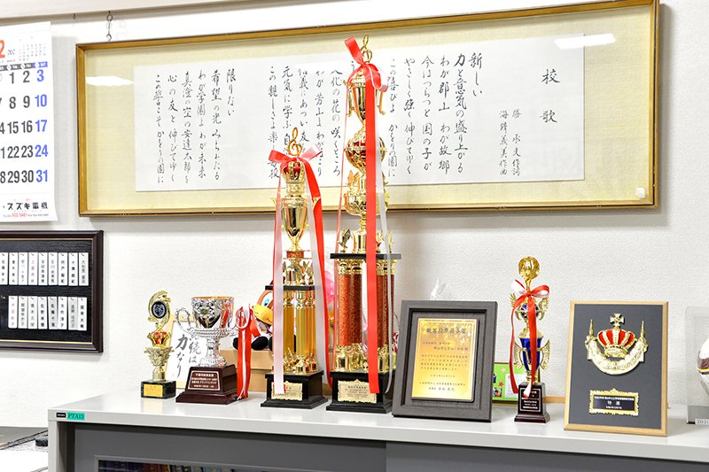 児童の活躍に贈られたトロフィーや盾が飾られている