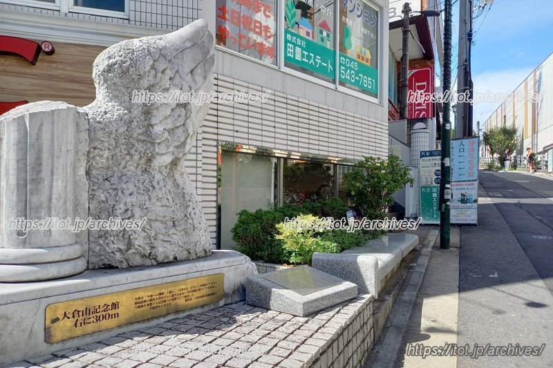 記念館坂の下にある像。「当地域を象徴する記念館への道標として建設」とある