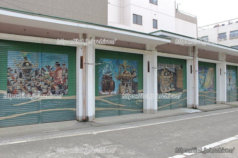 地元アーティストの手による神輿の絵で彩られた倉庫のシャッター